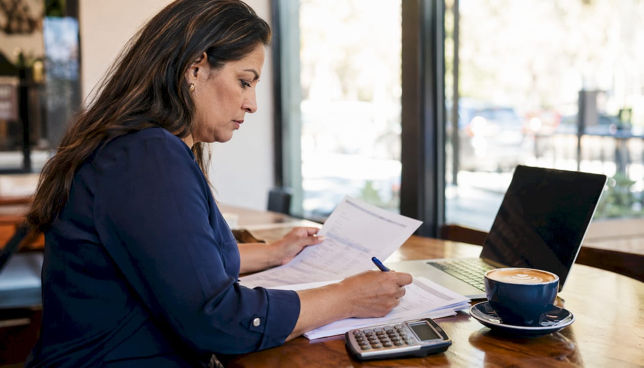 Woman reviewing mortgage documents at home table
